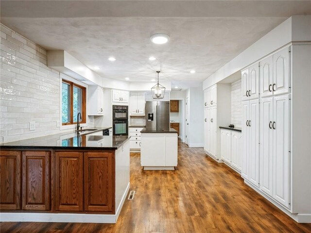 kitchen with dark hardwood / wood-style floors, stainless steel fridge, and backsplash