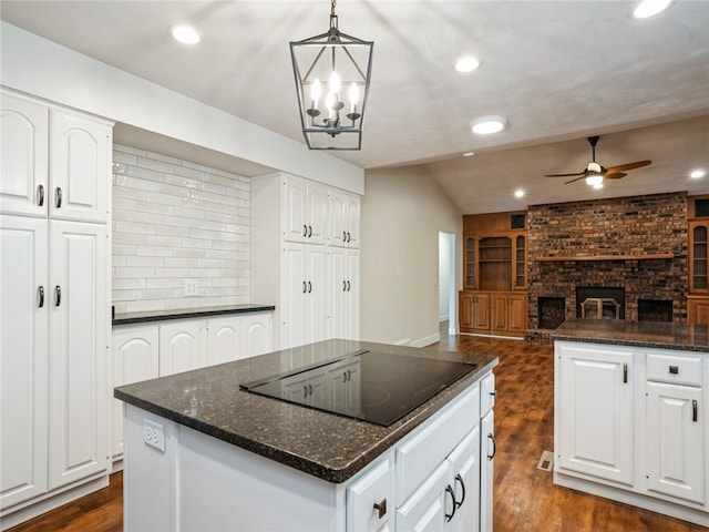 kitchen featuring a center island, white cabinetry, and a brick fireplace