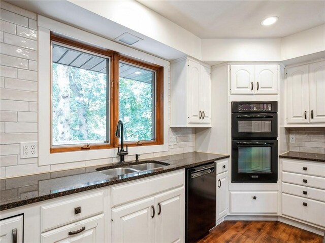 kitchen featuring dark stone countertops, white cabinets, dark hardwood / wood-style floors, black appliances, and sink