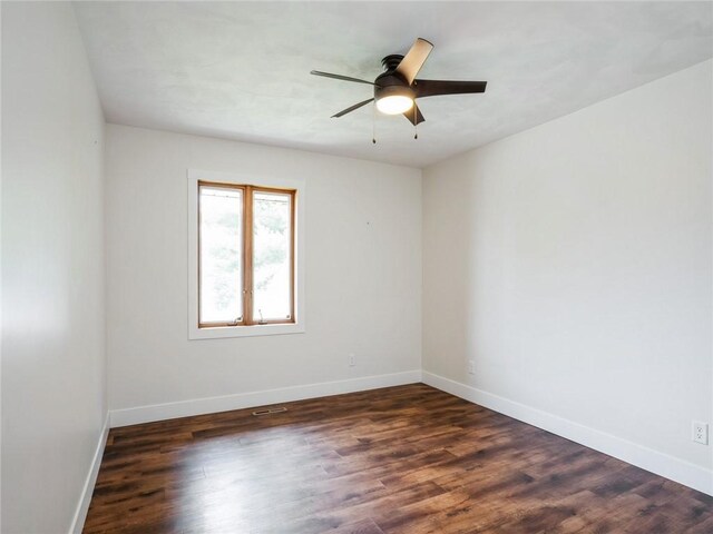 empty room with dark wood-type flooring and ceiling fan