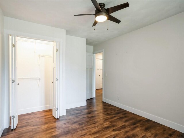 unfurnished bedroom featuring dark wood-type flooring, ceiling fan, and a closet