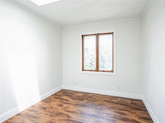 empty room featuring wood-type flooring and crown molding