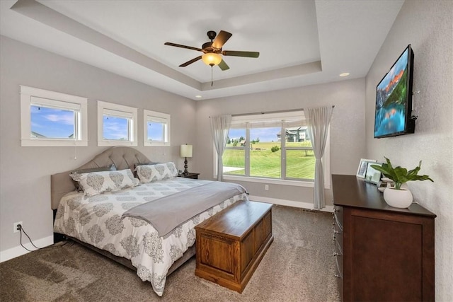 bedroom with ceiling fan, a raised ceiling, and carpet floors