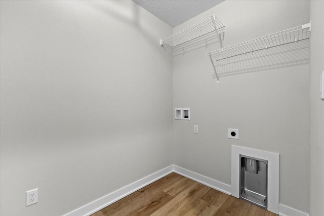 laundry room featuring electric dryer hookup, hardwood / wood-style floors, hookup for a washing machine, and a textured ceiling