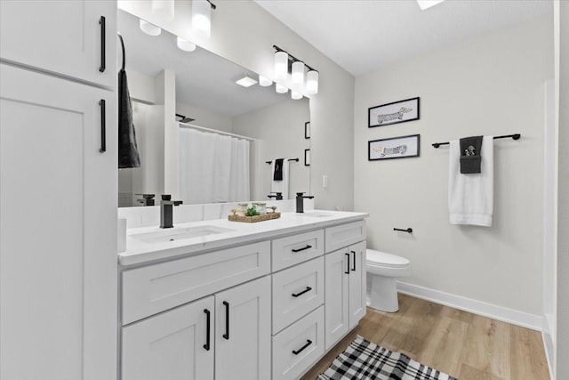 bathroom featuring toilet, a shower with curtain, wood-type flooring, a textured ceiling, and vanity