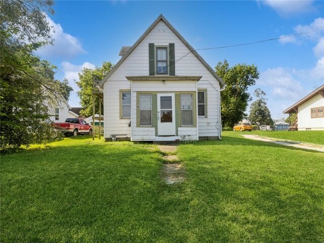 rear view of house featuring a yard