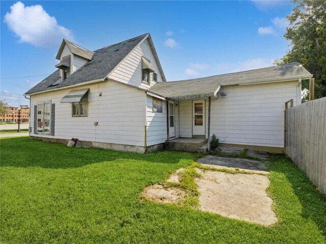 rear view of property with a lawn