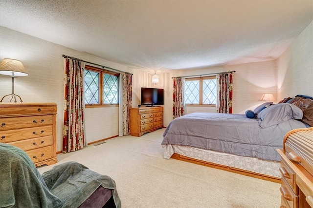 bedroom featuring a textured ceiling and light colored carpet