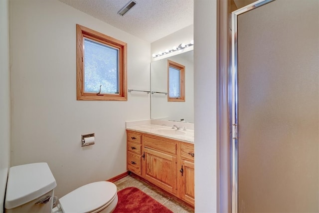 bathroom featuring tile patterned flooring, vanity, toilet, and a textured ceiling