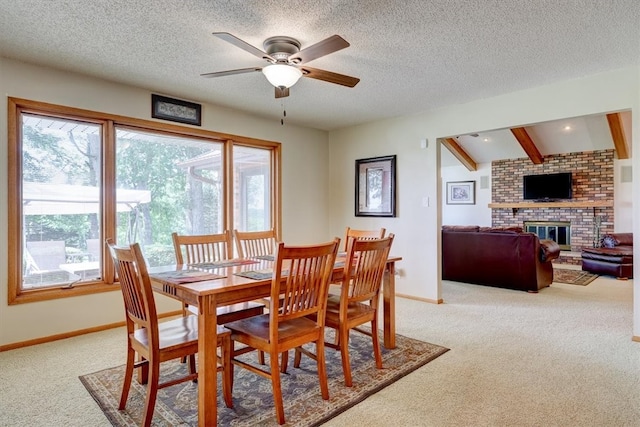 carpeted dining space featuring plenty of natural light, ceiling fan, and a fireplace