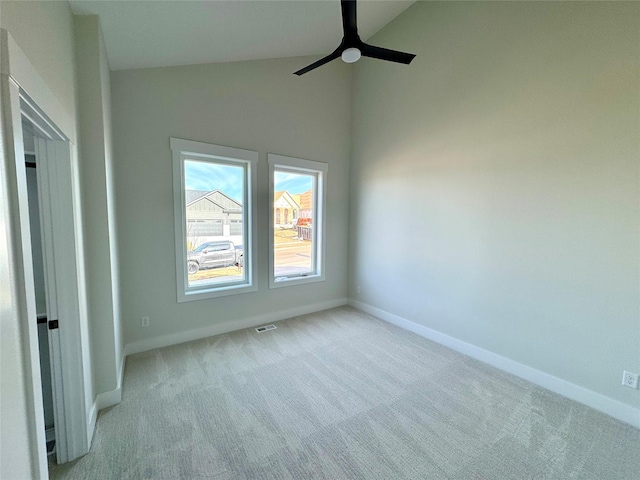 empty room featuring light carpet, high vaulted ceiling, and ceiling fan