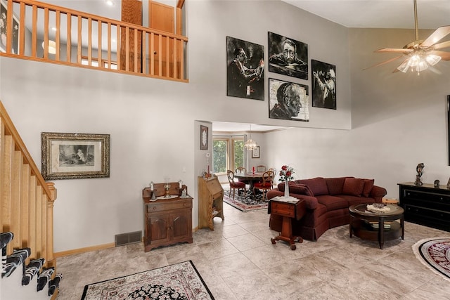 living room with ceiling fan and a high ceiling