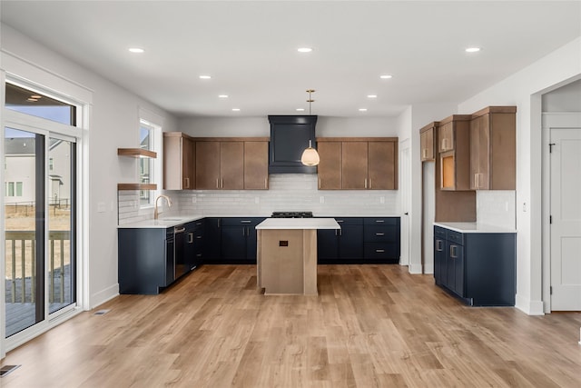 kitchen featuring decorative backsplash, pendant lighting, a center island, and light wood-type flooring