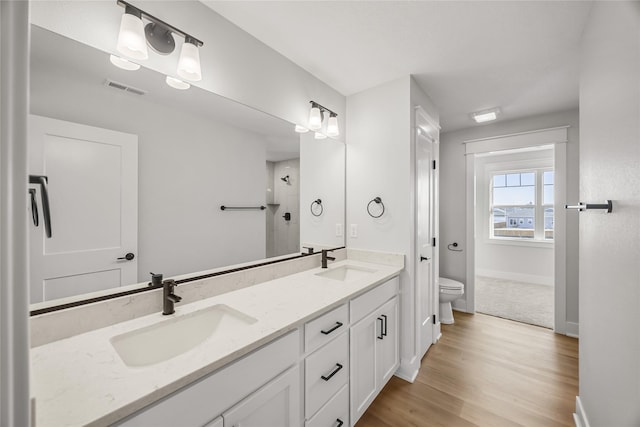 bathroom featuring hardwood / wood-style flooring, toilet, a shower, and vanity