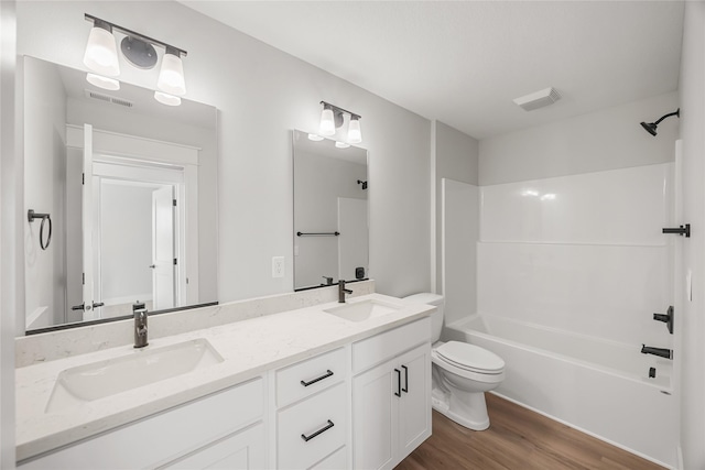 full bathroom with tub / shower combination, hardwood / wood-style floors, toilet, and vanity