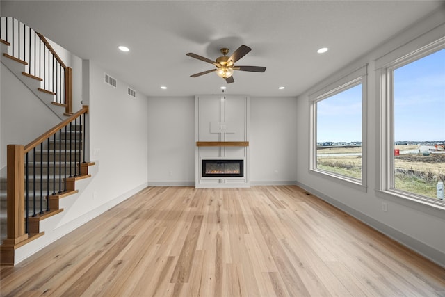 unfurnished living room featuring ceiling fan and light hardwood / wood-style flooring