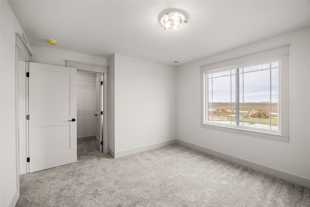 unfurnished bedroom featuring a closet and light colored carpet