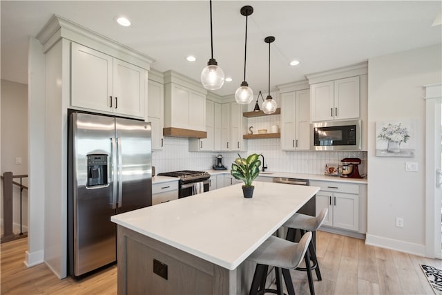 kitchen featuring pendant lighting, tasteful backsplash, a kitchen bar, a center island, and stainless steel appliances