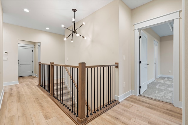 hall featuring an inviting chandelier and light wood-type flooring