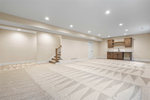 basement with light carpet and indoor bar