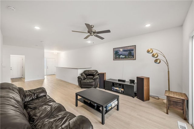 living room with ceiling fan and light hardwood / wood-style flooring