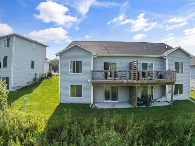 rear view of property with a wooden deck, a patio area, and a lawn