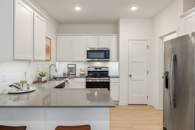 96 Keeneland Ct, Pleasant Hill, IA 50327 - kitchen with light wood-style floors, a peninsula, white cabinets, appliances with stainless steel finishes, and a sink