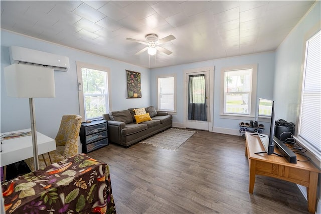 living room with hardwood / wood-style flooring, an AC wall unit, ceiling fan, and a barn door