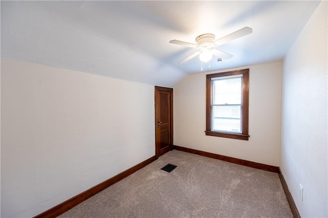 empty room with lofted ceiling, light carpet, and ceiling fan