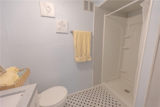 bathroom featuring vanity, toilet, and a shower