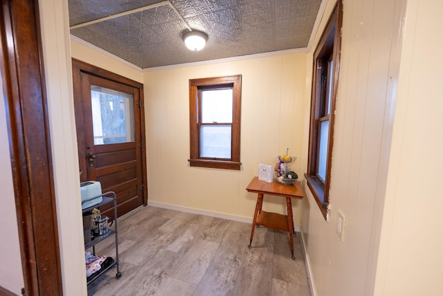 entrance foyer featuring crown molding and light wood-type flooring