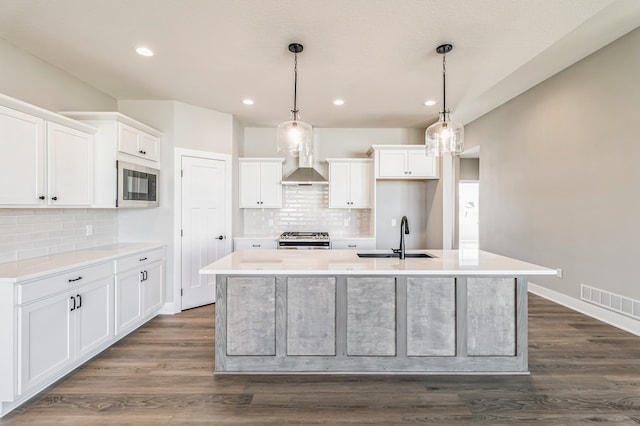 kitchen featuring dark hardwood / wood-style flooring, a kitchen island with sink, sink, and white cabinets