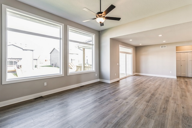 empty room with hardwood / wood-style floors and ceiling fan