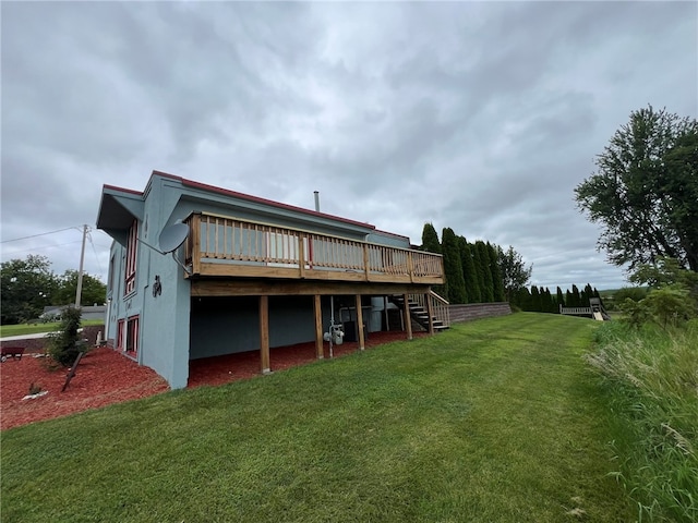 back of property featuring a wooden deck and a lawn