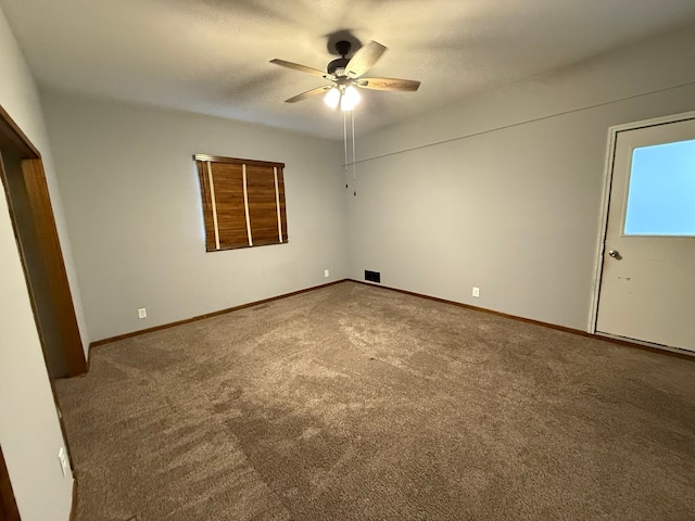 carpeted spare room featuring ceiling fan