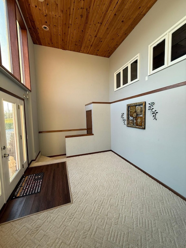 carpeted empty room featuring wooden ceiling