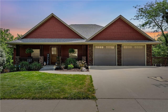 craftsman inspired home featuring a garage, a porch, and a lawn