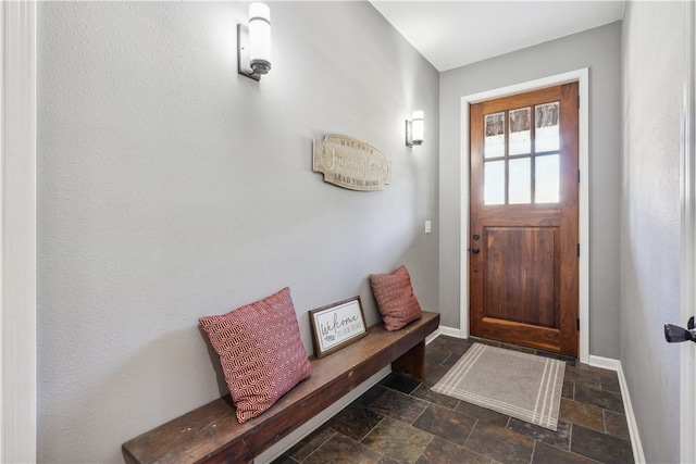 entryway with dark tile patterned flooring