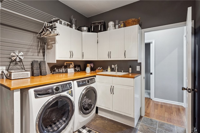 washroom featuring sink, washer and dryer, cabinets, and hardwood / wood-style floors