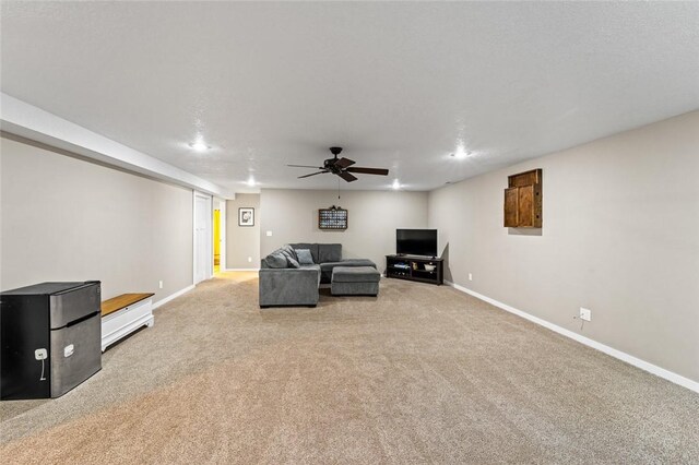 carpeted living room featuring ceiling fan