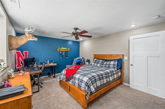 carpeted bedroom featuring a textured ceiling and ceiling fan