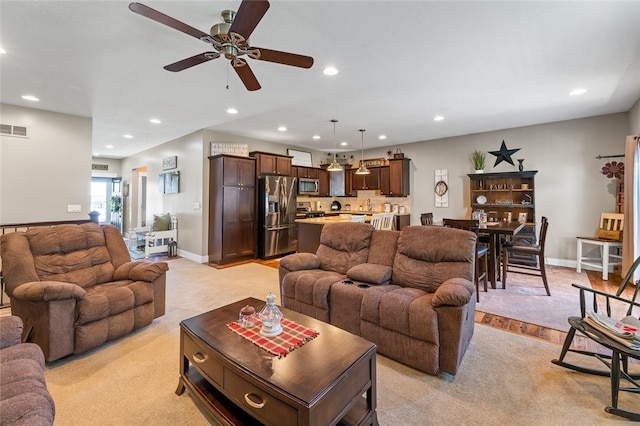 living room featuring light carpet and ceiling fan