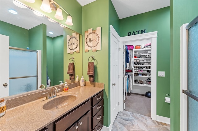 bathroom featuring a shower with door, vanity, and tile patterned floors