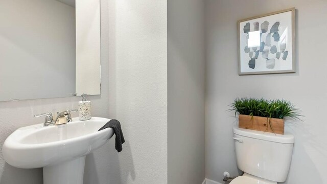 half bathroom featuring toilet and a sink