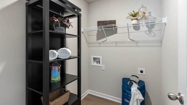 washroom featuring dark wood-style flooring, baseboards, electric dryer hookup, washer hookup, and laundry area
