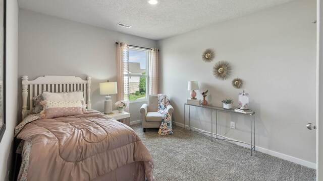 carpeted bedroom featuring a textured ceiling, baseboards, and visible vents