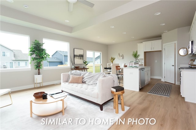 living room with light hardwood / wood-style flooring and ceiling fan