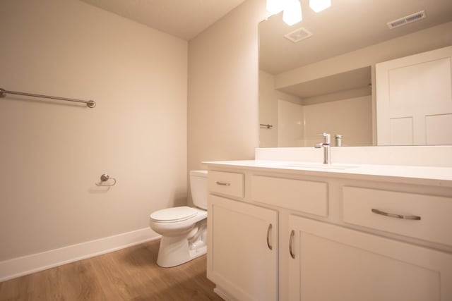 1303 NW Benjamin Dr, Ankeny, IA 50023 - bathroom featuring toilet, baseboards, visible vents, wood finished floors, and vanity