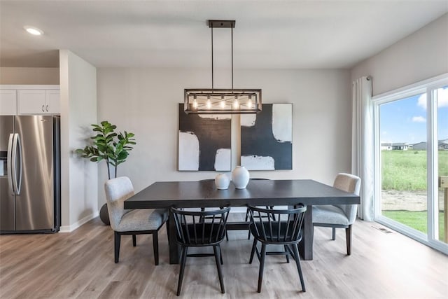 dining space with light hardwood / wood-style flooring and a healthy amount of sunlight