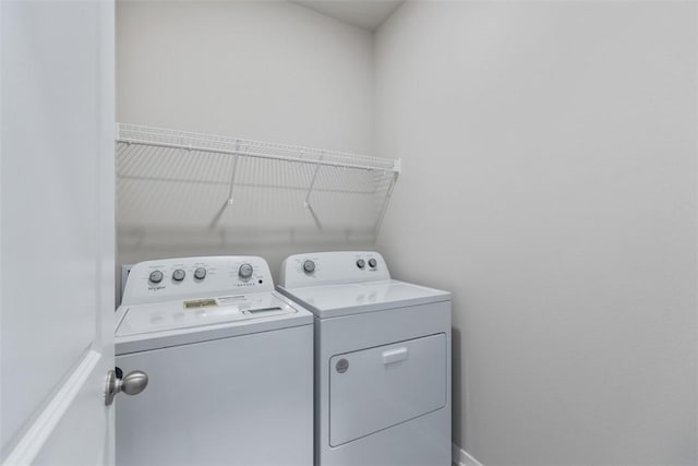 clothes washing area with washer and clothes dryer